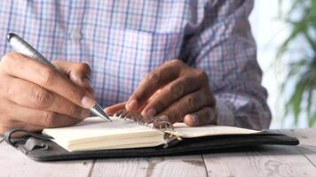 A man writing in a notebook with a pen video