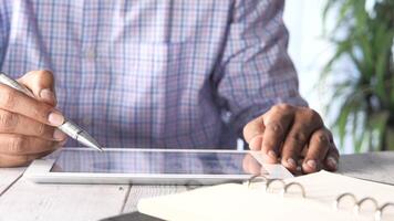 A man is using a pen and tablet on a desk video