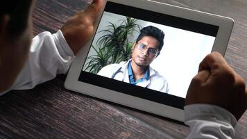 A man is holding a tablet with a of a doctor on it video