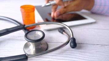 A tablet and a stethoscope on a wooden table video