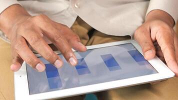 A person is using a tablet computer with a bar chart video