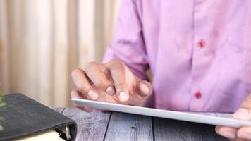 A man is using a tablet computer on a wooden table video