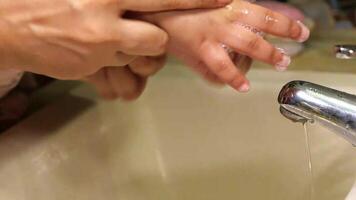A person washing their hands with soap in a sink video