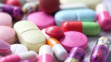 Many different colored pills and tablets are scattered on a table video