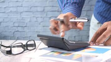 A man is using a calculator to make a financial decision video