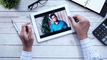 Man using tablet to call with his family video