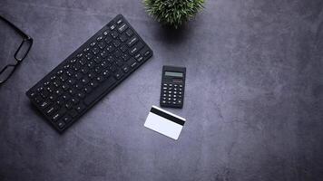 A calculator, a pen, a credit card and a pair of glasses are placed on a desk video