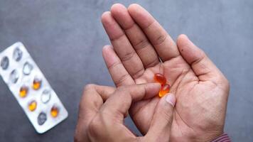 A person holding a pill with a capsule in their hand video
