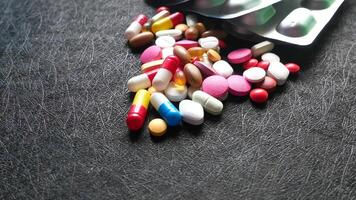 A pile of pills and capsules on a black surface video