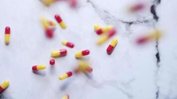Pills falling from the sky on a marble surface video