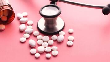 A stethoscope and pills on a pink background video