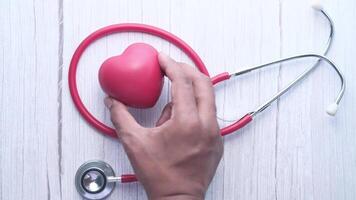 A person holding a red heart shaped object with a stethoscope video