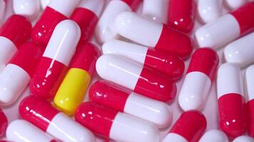 Pills are arranged in a pile with a yellow and red one in the middle video