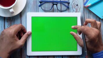 Hands on tablet with green screen video