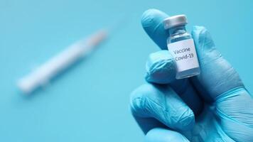 A hand holding a syringe and a vial of vaccine video