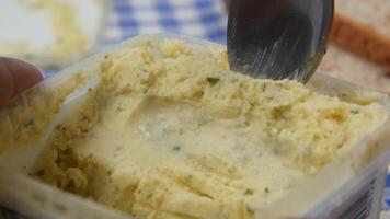 A person is holding a spoon over a container of butter video
