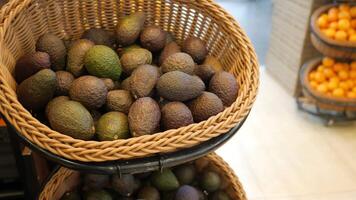 A basket filled with avocados in a store video
