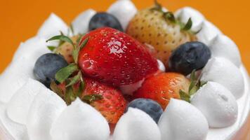 A strawberry cake with whipped cream and berries video