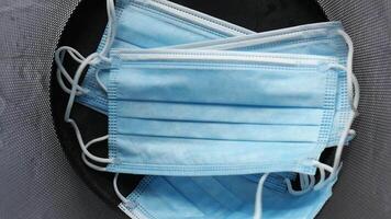 A pair of blue surgical masks are sitting in a trash can video