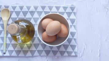 Eggs and oil on a table with wooden spoons video