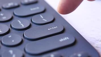 A person is pressing the enter button on a black keyboard video