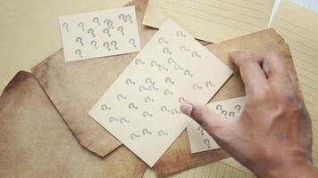 A person is holding a piece of paper with a piece of paper with question marks on it video