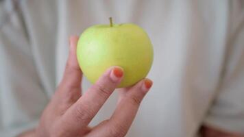 A Fresh Green Apple is Being Held in a Hand, with a CloseUp View of Its Vibrant Details video