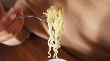 An Individual Enjoying a Bowl of Noodles with a Fork in a Lovely and Cozy Setting video