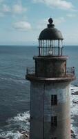 Haut vue de abandonné phare avec mer vagues. agrafe. incroyable paysage de abandonné phare dans océan sur ensoleillé journée. paysage marin avec abandonné phare sur rochers et magnifique bleu vagues video