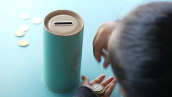 A person putting coins into a coin box video