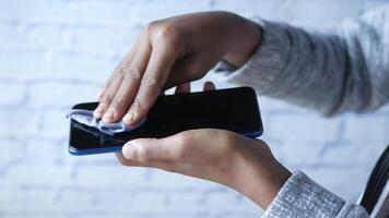 A person is using a phone to wipe off a screen video