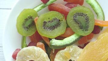 A plate of fruit and vegetables with kiwi, oranges, and kiwi video