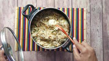 A person is stirring rice in a pan with a spoon video