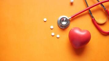 A stethoscope and a heart on an orange background video