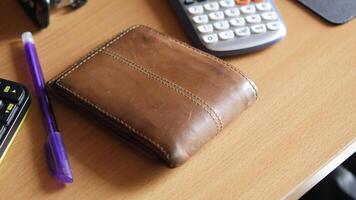 A wallet, pen, calculator and a calculator are on a desk video