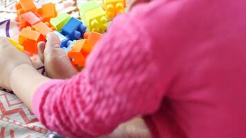 A child playing with colorful blocks on a bed video