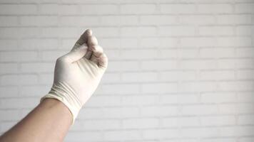 A person wearing a white glove is holding up a finger video