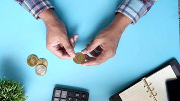 Man's hands holding coins on desk with calculator and notebook video