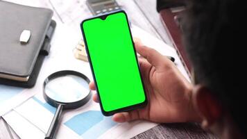 Man using smartphone with green screen on desk video