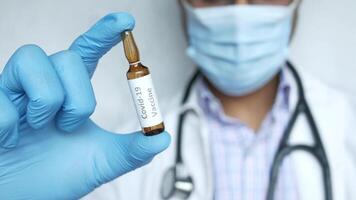 A doctor holding a vial of a vaccine video