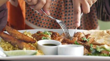A woman is holding a fork and knife over a plate of food video