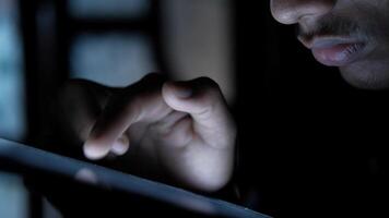 en man är använder sig av en läsplatta dator i de mörk video
