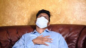 A man wearing a face mask sitting on a couch video