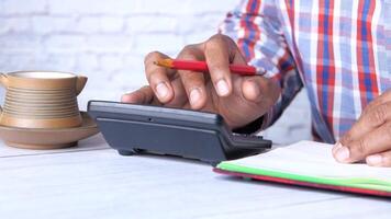 A man is using a calculator to make a calculation video