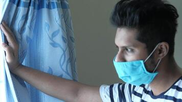 A man wearing a face mask in front of a window video