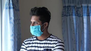 A man wearing a face mask in front of a window video
