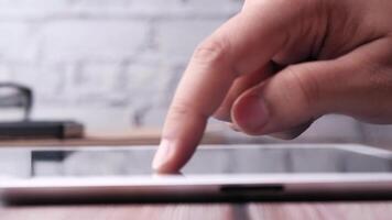 A person is touching a tablet on a table video