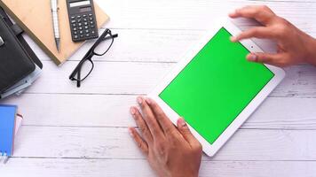 Hands on tablet with green screen on wooden desk video