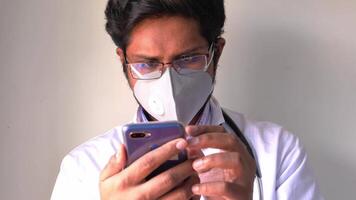 A man wearing a face mask and holding a cell phone video