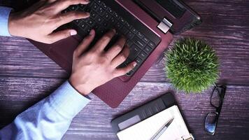 A person typing on a laptop computer with a pen and glasses video